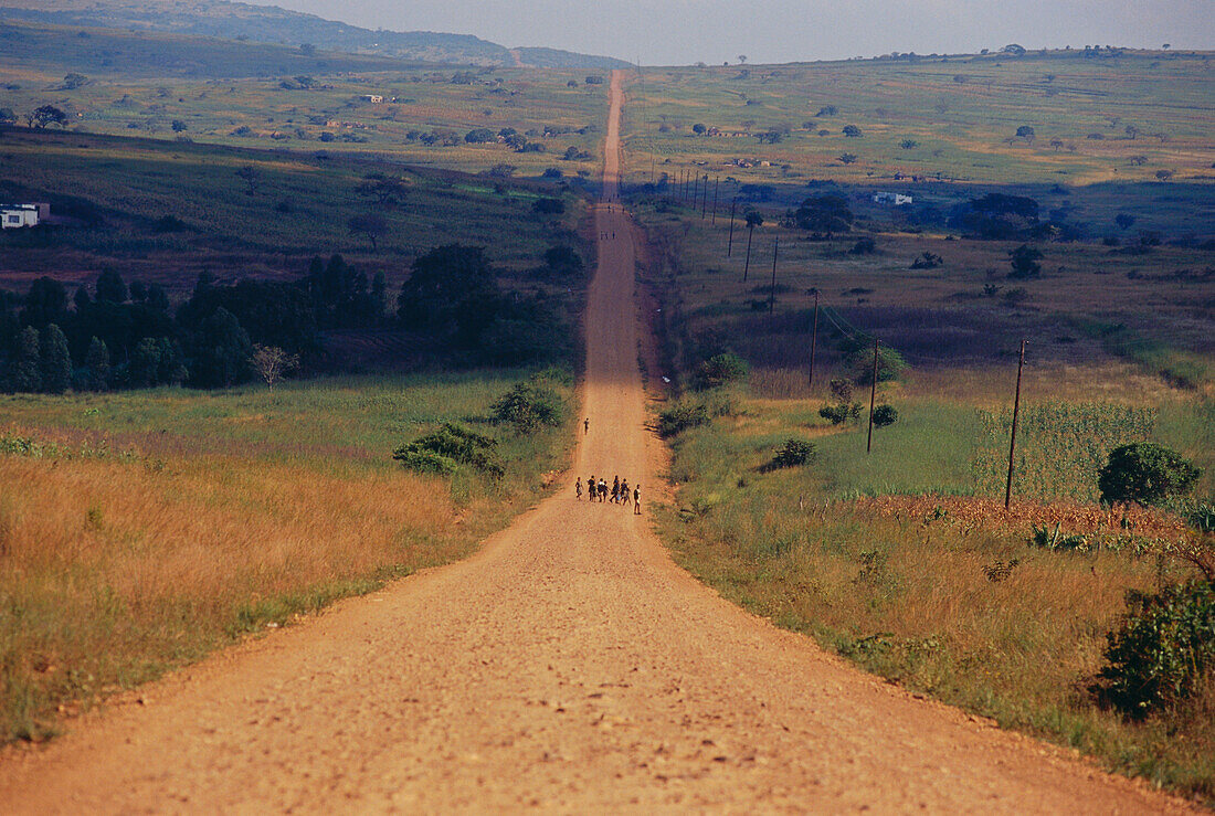 Kinder gehen auf einer staubigen Strasse, Lebombo Berge, Swasiland, Südafrika, Afrika