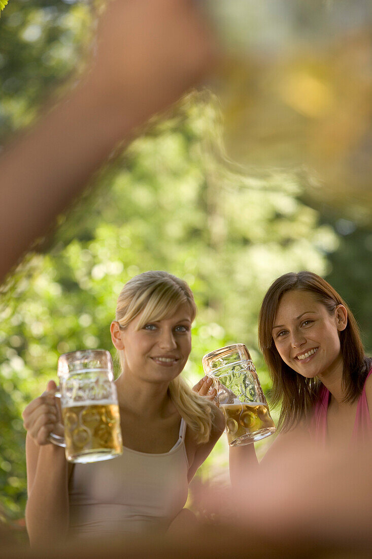 Flirt in Biergarten, Zwei junge Frauen beim Flirten in Biergarten, Starnberger See, Bayern, Deutschland