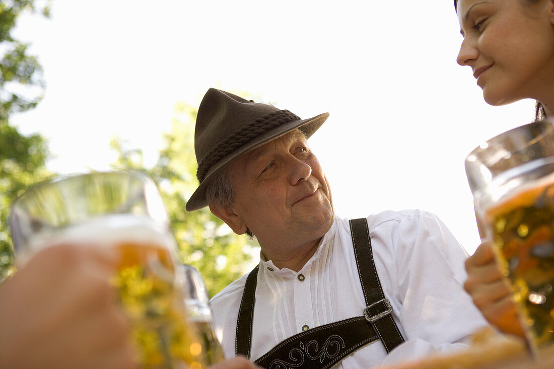 Grandfather and granddaughter looking at each other in beer garden, Munich, Bavaria
