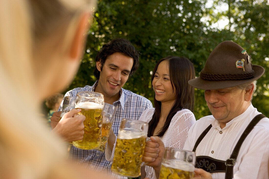 Freunde stoßen im Biergarten an, Bayern, Deutschland