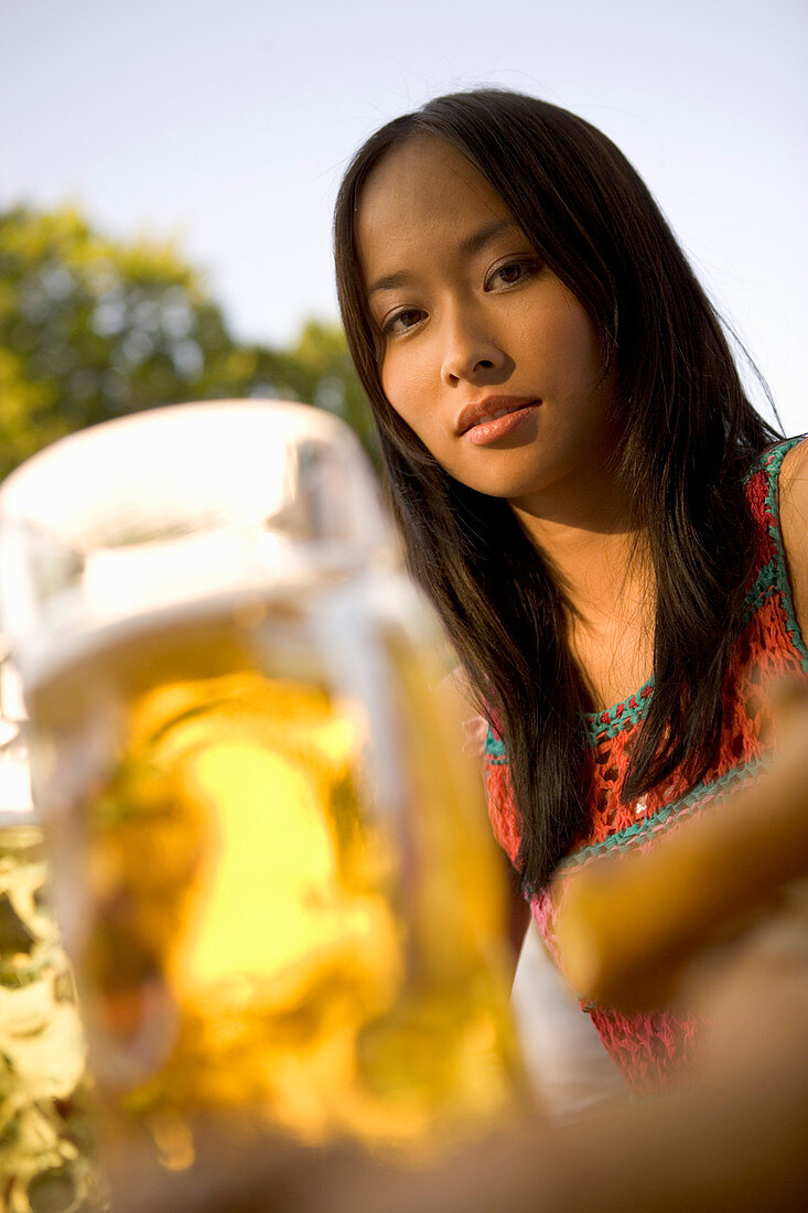 Young woman with beer stein in beer garden, Munich, Bavaria