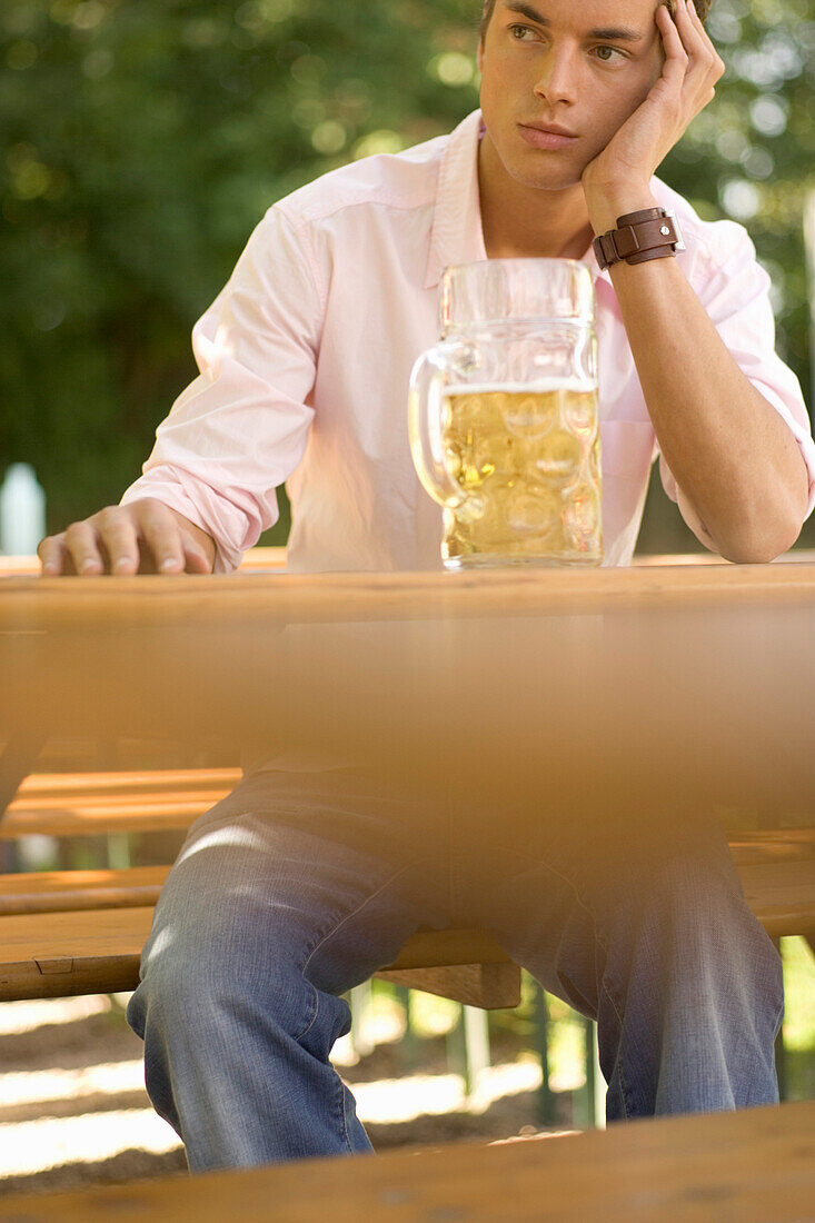 Young man waiting for someone in beer garden, Munich, Bavaria