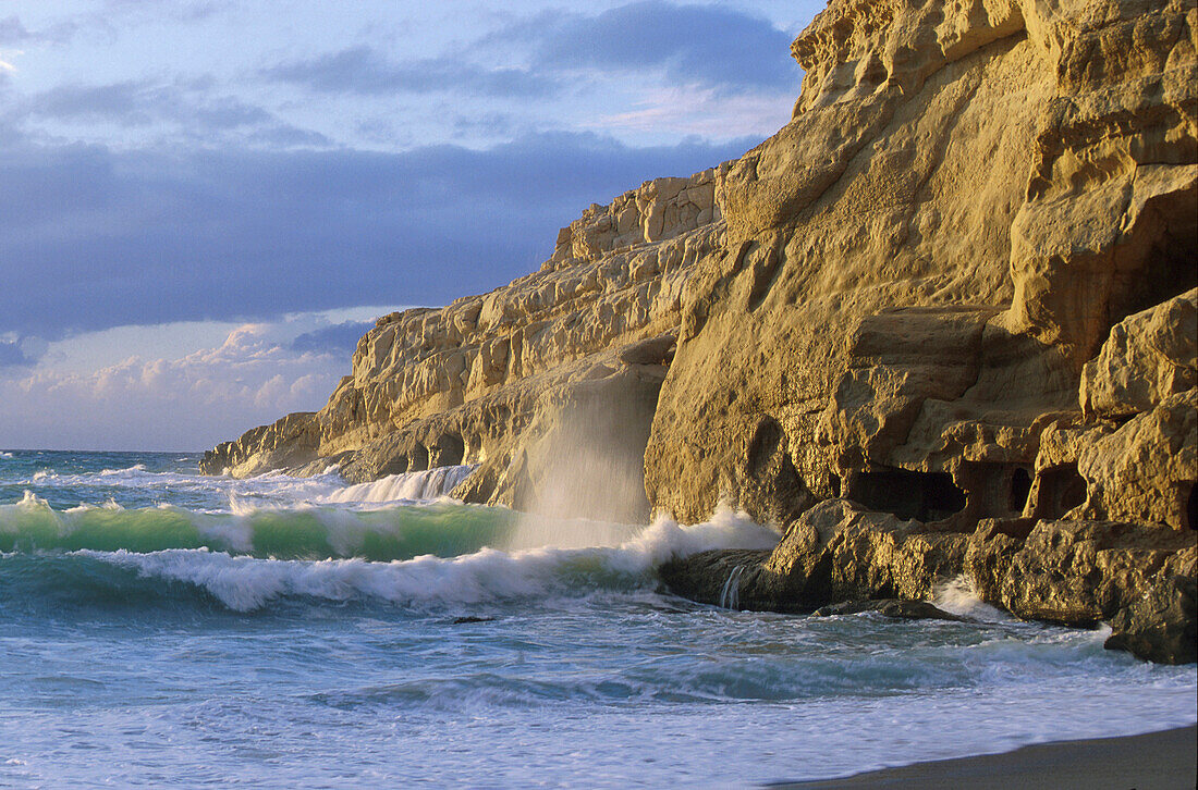 Sunlit cliff in the surge, Matala Beach, Crete, Greece