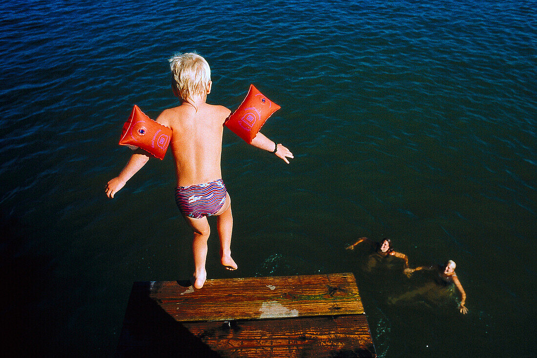 Junge mit Schwimmflügel springt ins Wasser, See, Lernen, Kindheit