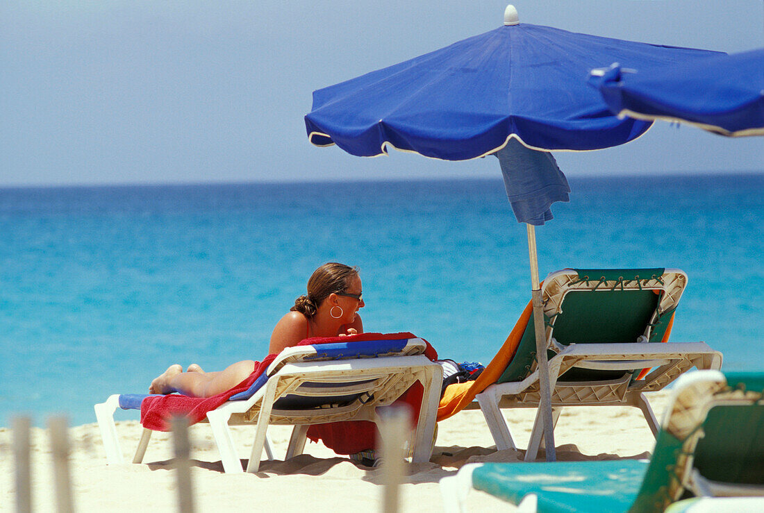 Frau liegt auf einer Sonnenliege am Strand, Santa Maria, Sal, Kap Verde, Afrika