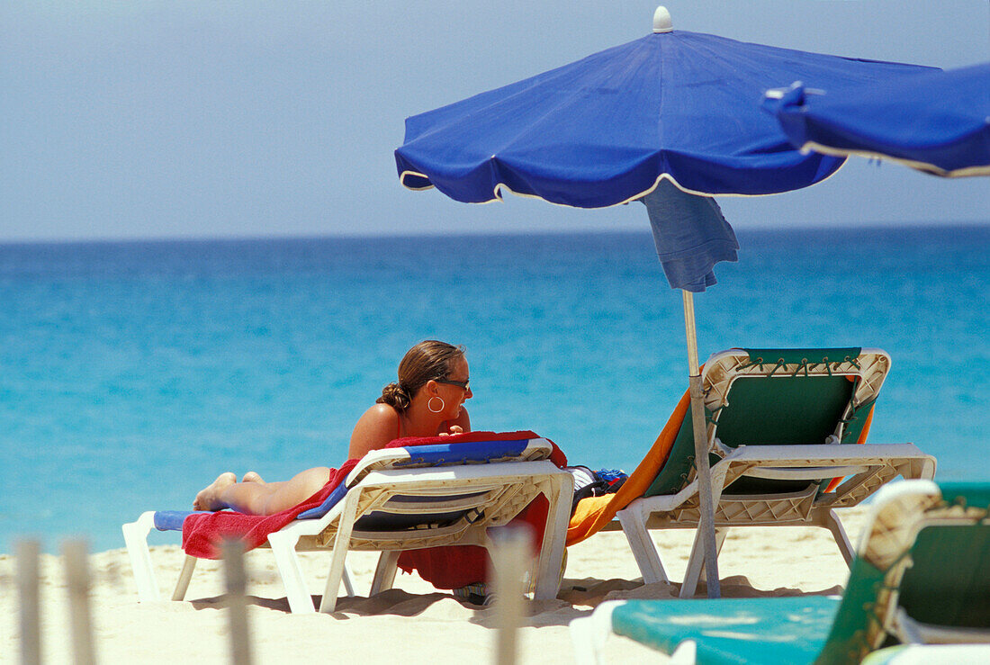 Woman lying on sunlounger on the beach, Santa Maria, Sal, Cape Verde Islands, Africa