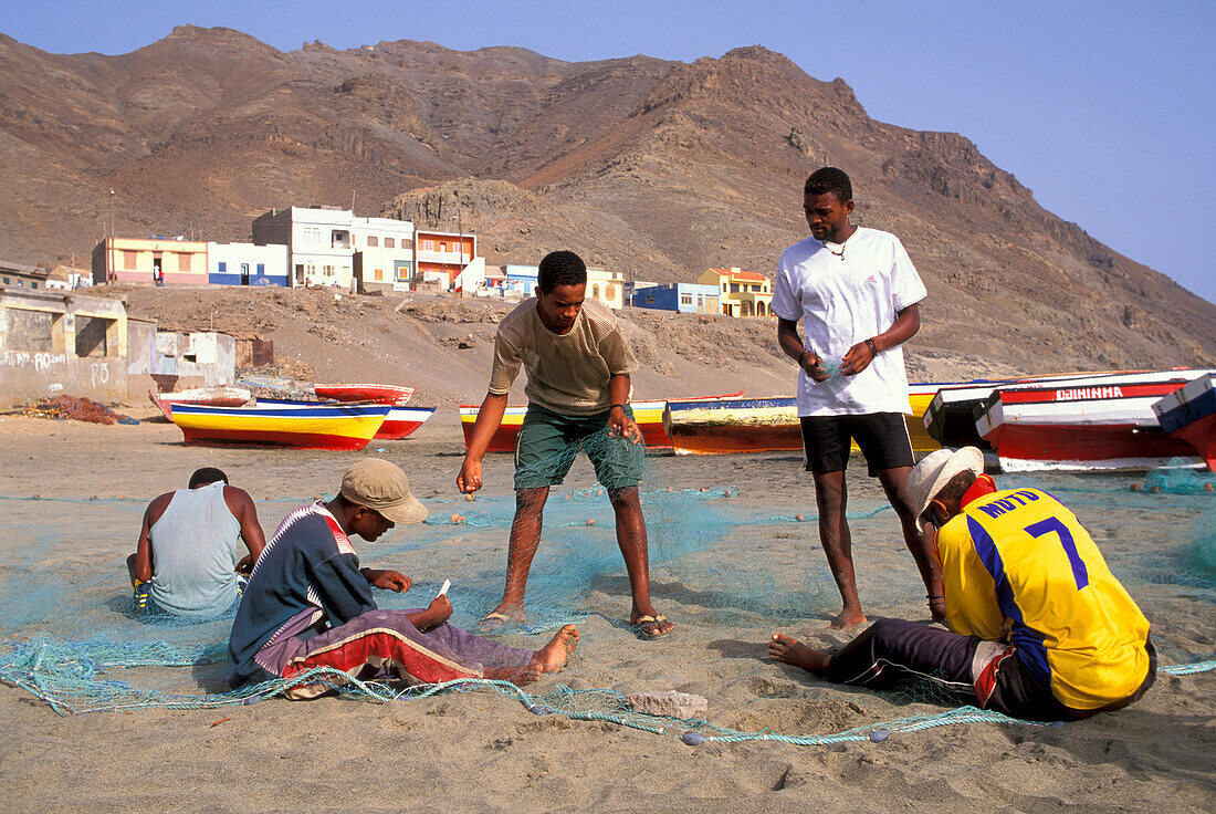 Fishermen repairing nets on the beach of Sao Pedro, Sao Vicente, Cape Verde Islands, Africa