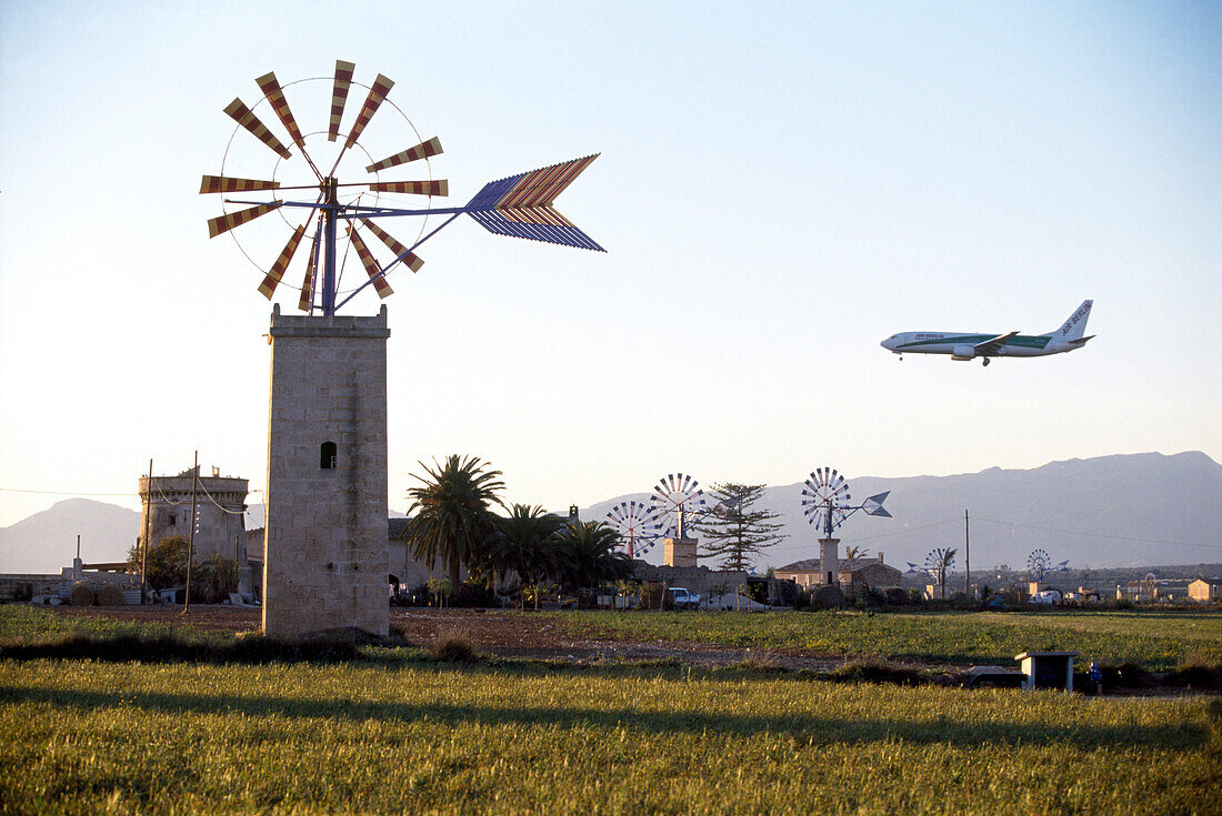 Windmühlen und ein Flugzeug vor blauem Himmel, Mallorca, Balearen, Spanien