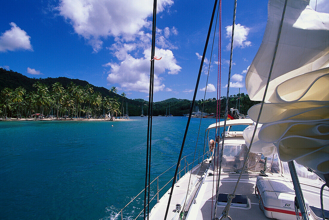 Blick von einem Segelboot zu einem Palmenstrand unter blauem Himmel, Marigot Bay, St. Lucia, Karibik, Amerika