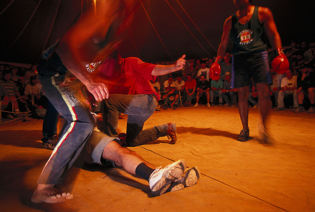 Referee helping knocked out boxer, boxing event, Fred Brophy's Boxing Troupe, Queensland, Australia