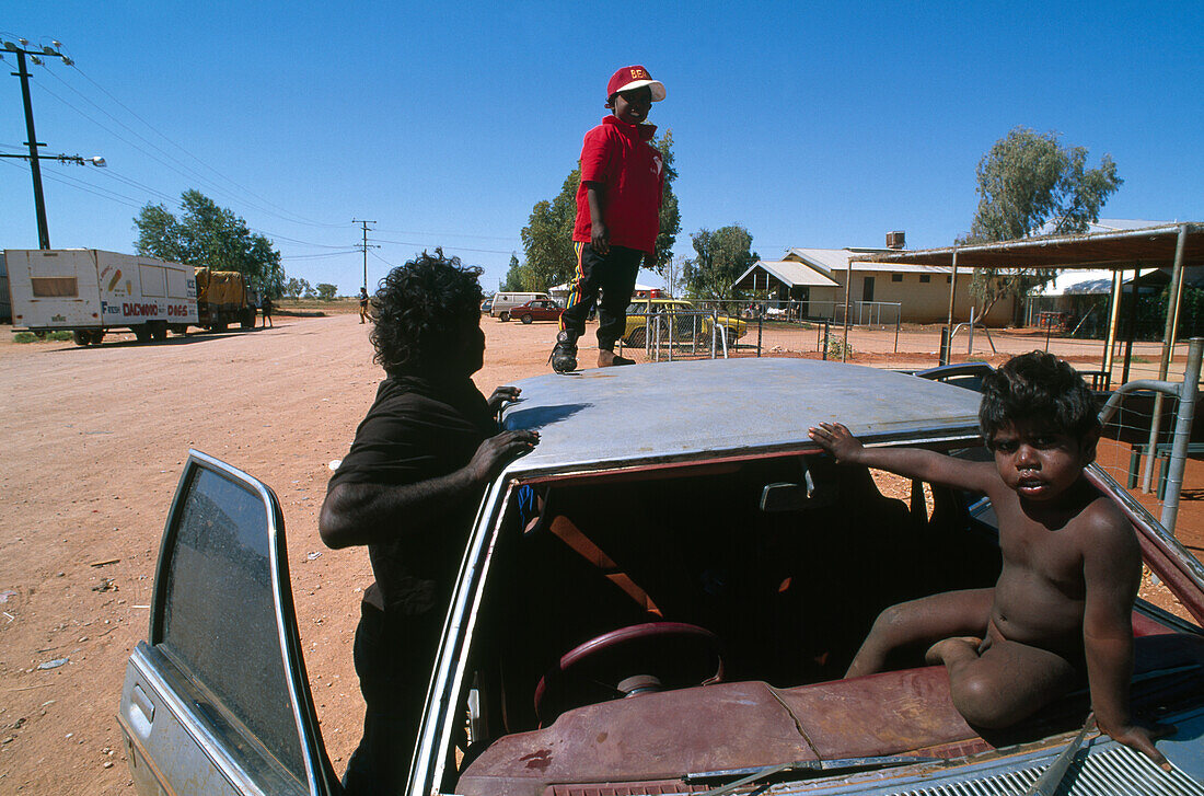 Kinder spielen auf Auto, Community Lake Nash, Northern Territory, Australien