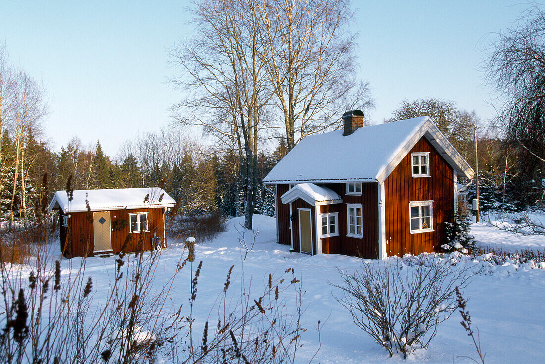 Holzhäuser in verschneiter Landschaft, Västergötland, Schweden