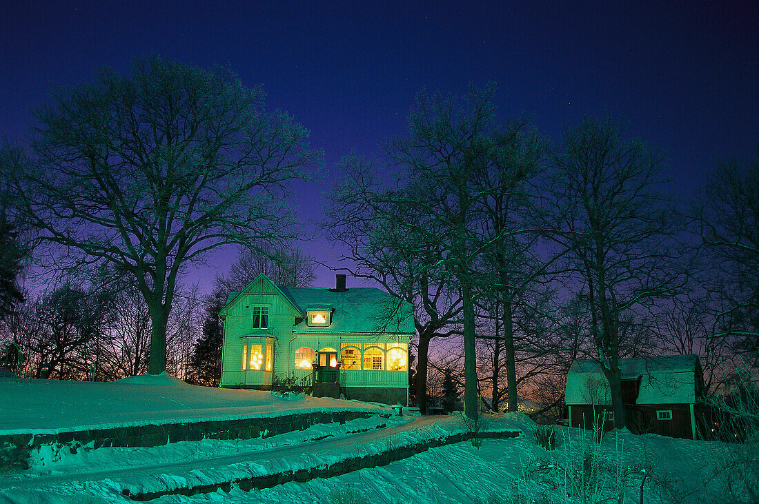 Wohnhaus mit erleuchteten Fenstern an einem Winterabend, Kinna, Väster Götland, Schweden, Europa
