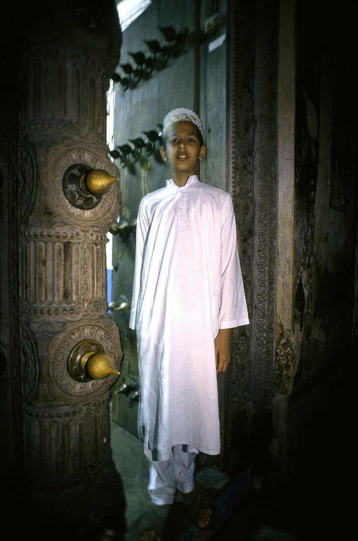 Muslim boy standing in a doorway, Stone Town, Zanzibar, Tanzania, Africa