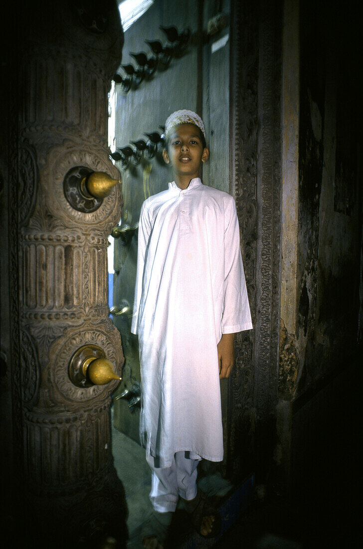 Muslimischer Junge steht in einem Eingang, Stone Town, Sansibar, Tansania, Afrika