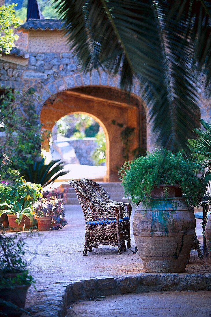 Basket-chair and plants at the courtyard of Finca Hotel de Reis, Valle de los Naranjos, Soller, Majorca, Spain, Europe
