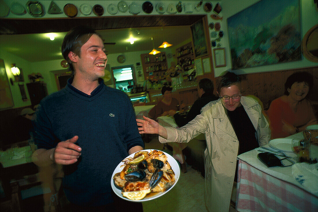 Kellner serviert Fischplatte, Restaurant, Puerto de Soller Mallorca, Spanien