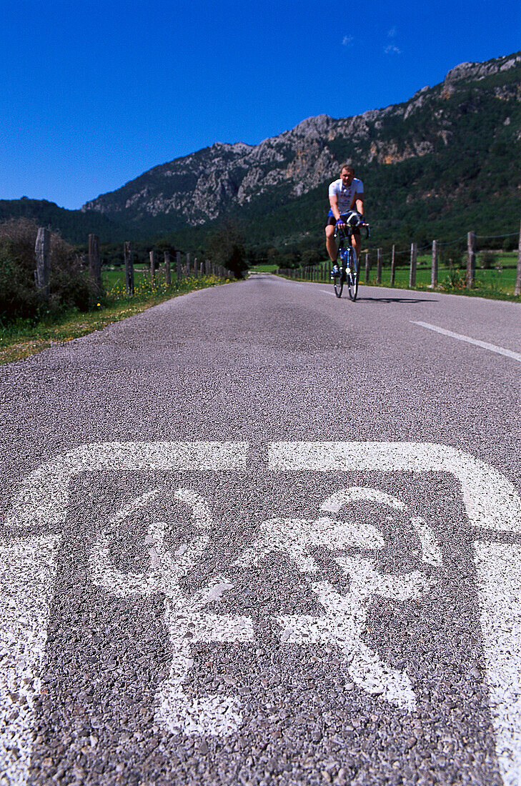 Radfahrer auf einer Landstrasse unter blauem Himmel, Tramuntana, Mallorca, Spanien, Europa