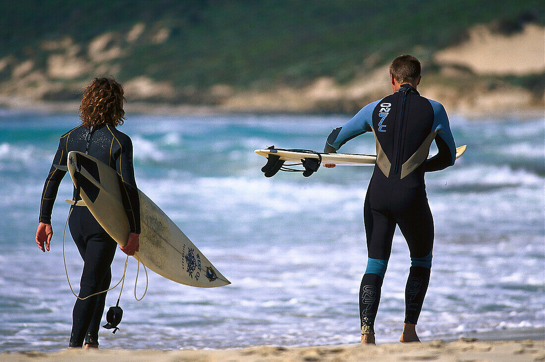 Surfers with surfboards on the beach, Smith' s Beach, Western Australia, Australia