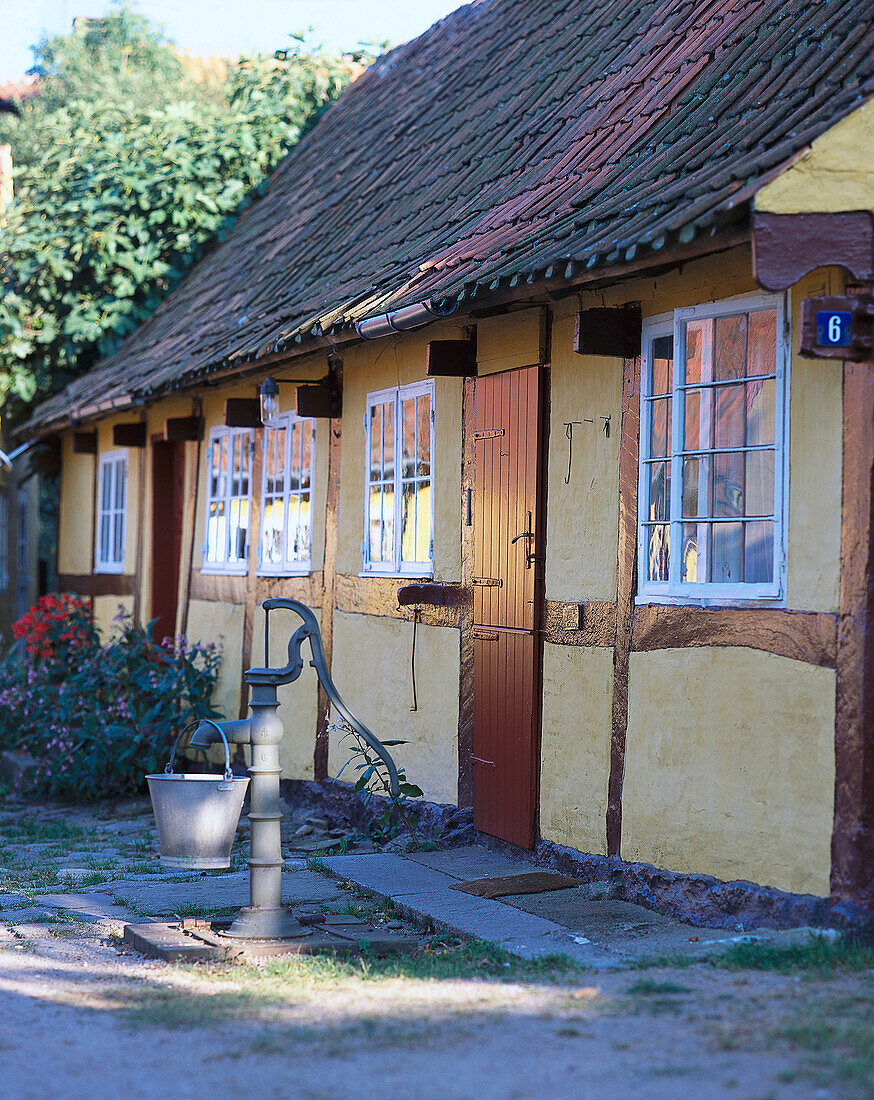 Water pump in front of half-timbered house, Svaneke, Bornholm, Denmark, Europe