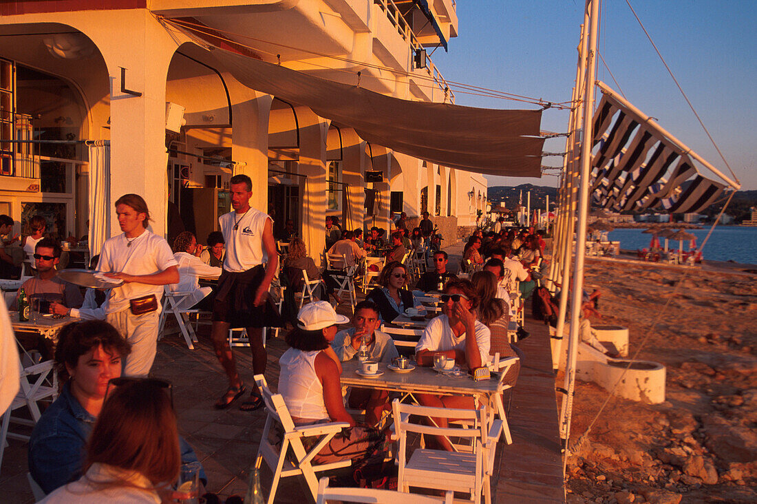 Menschen sitzen im Café del Mar im Licht der Abendsonne, San Antoni, Ibiza, Spanien, Europa