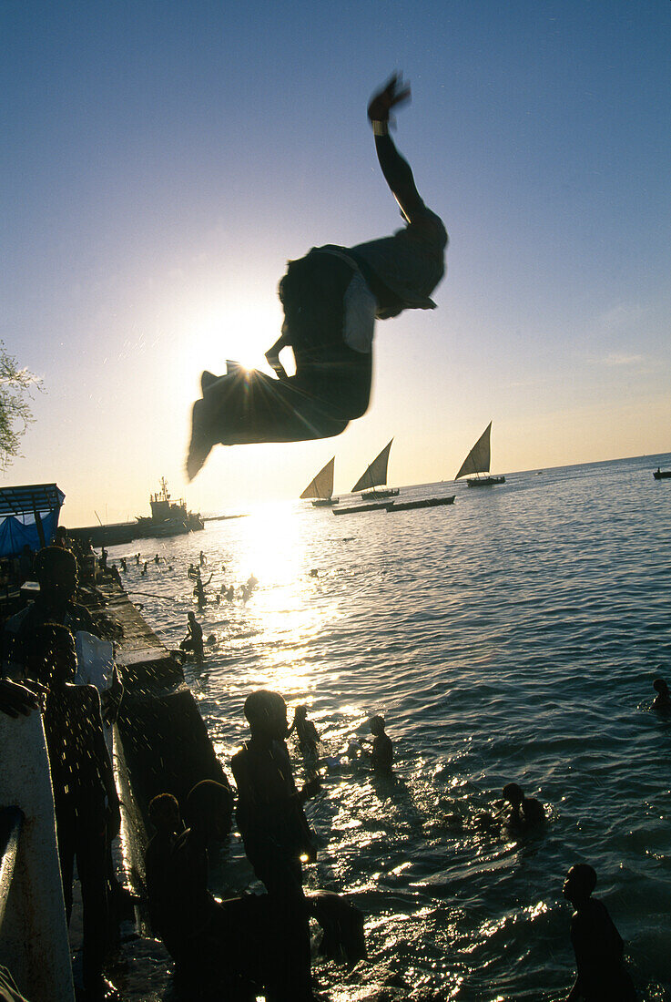 Children and Teenagers bathing at the harbour of Zanzibar, Tanzania, Africa