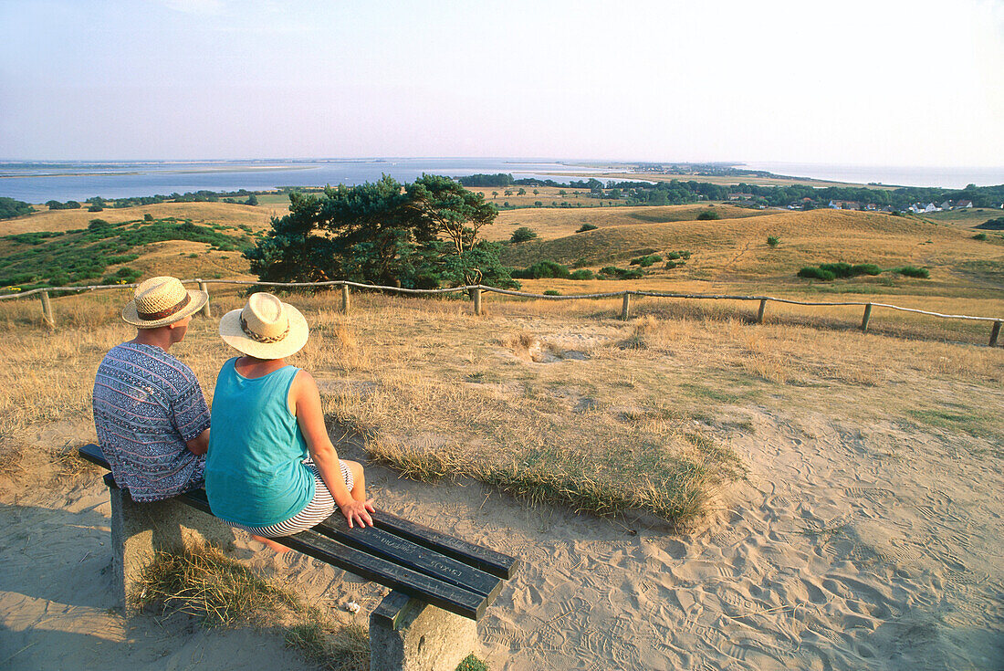 Couple sitting on a bench looking over Lake Hiddensee, Mecklenburg-Western Pomerania, Germany