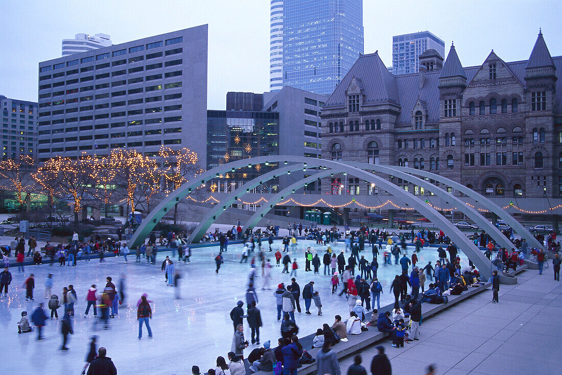 People on an ice skating rink in the evening, Nathan Philipps Square, Toronto, Canada, America