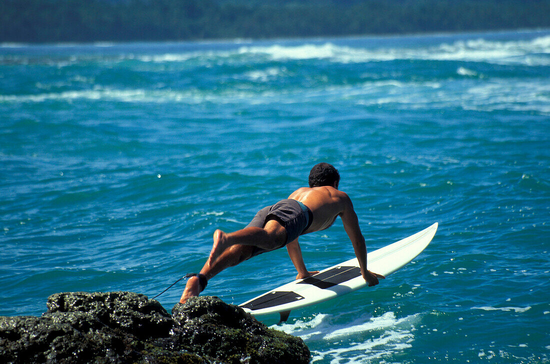 Surfer jumping into sea, Puerto Viejo, Costa Rica, Caribbean, Central America