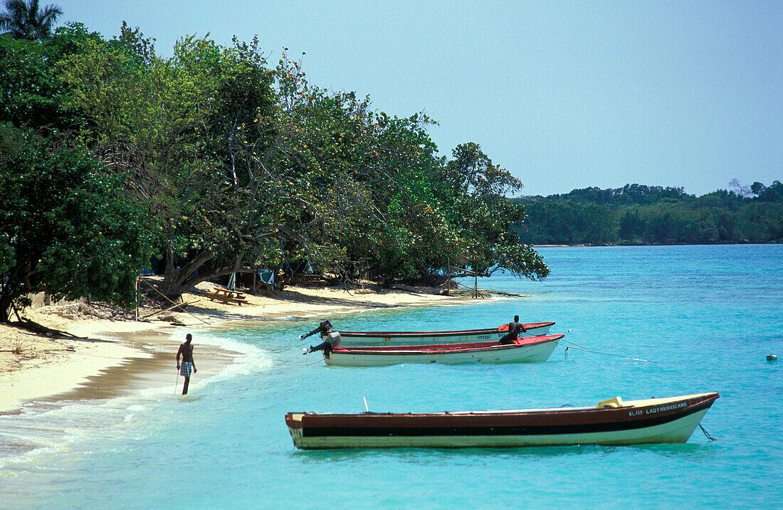 Fischerboote vor einem Strand im Sonnenlicht, Westmoreland, Jamaika, Karibik, Amerika