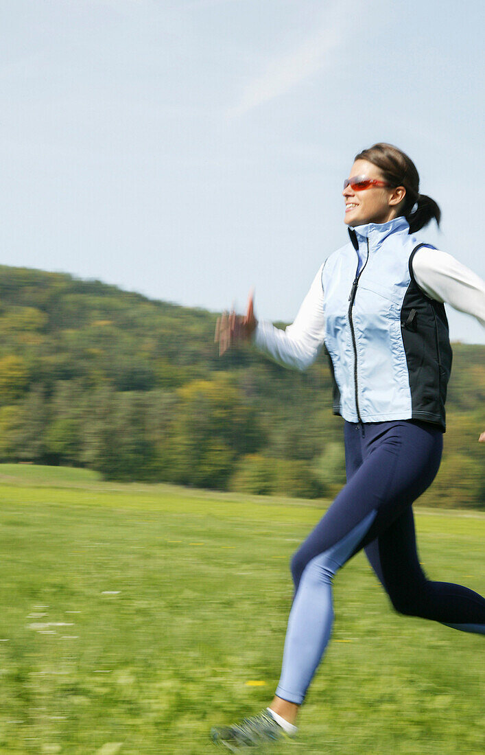 Frau mittleren Alters joggt im Grünen, Steiermark, Österreich