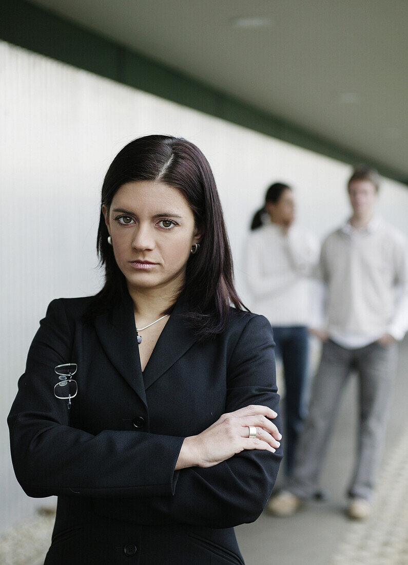 Buisness-woman looking at camera, two people in background, Business, Austria