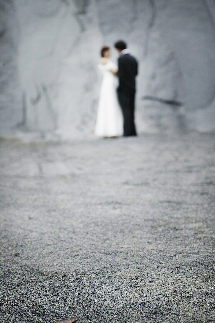 Brautpaar steht vor einer Felswand