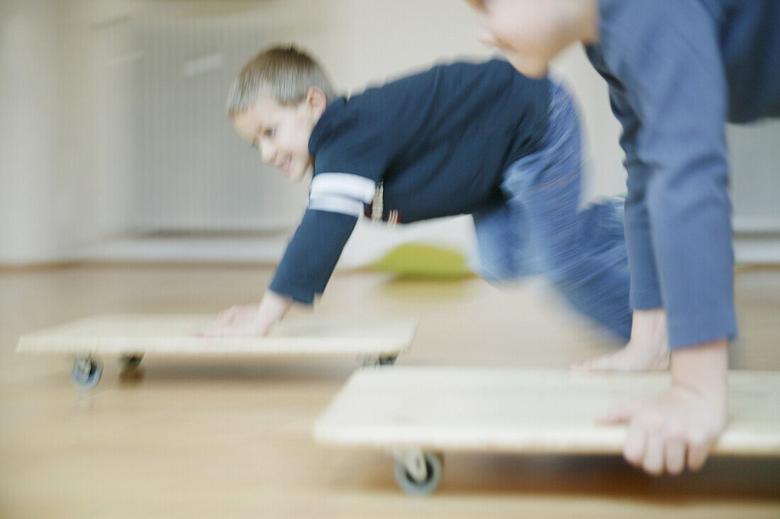 Zwei Jungen 3-5 Jahre, spielen mit Rollbrettern, Steiermark, Österreich