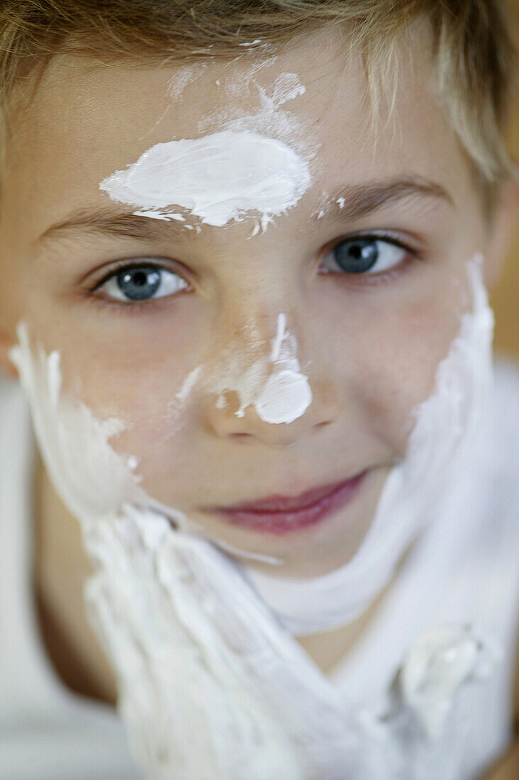 Boy applying moisturizer on face, Vienna, Austria