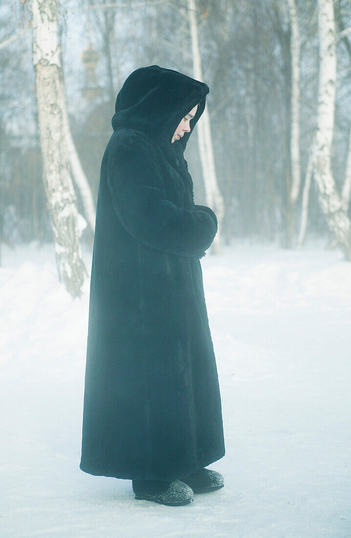 Eine Nonne steht im Schnee, Omsk, Sibirien