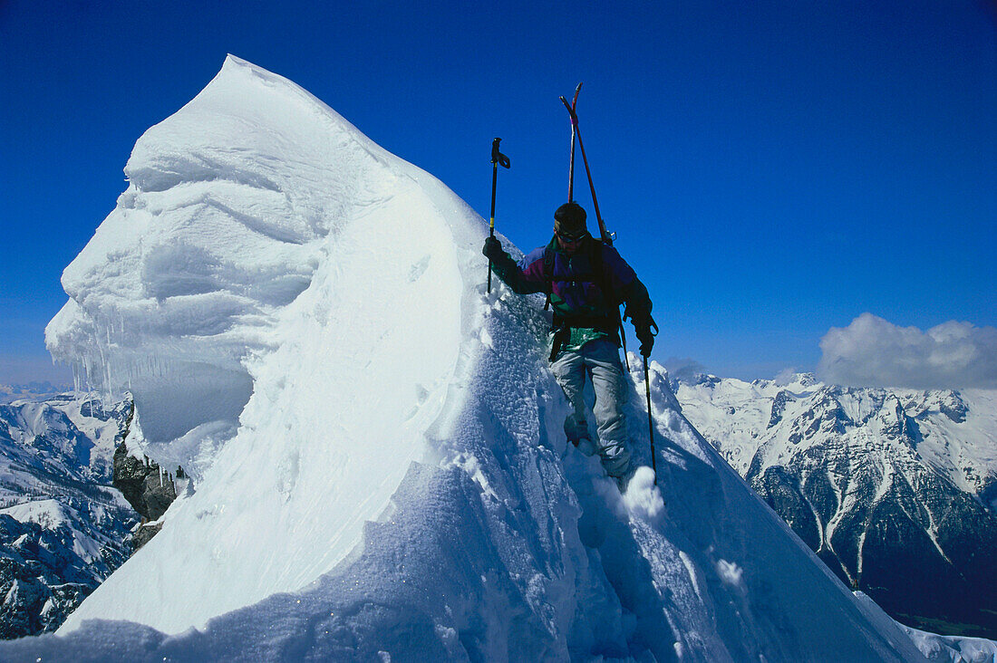 Man with skis in snow on summit, Totes Gebirge, Austria