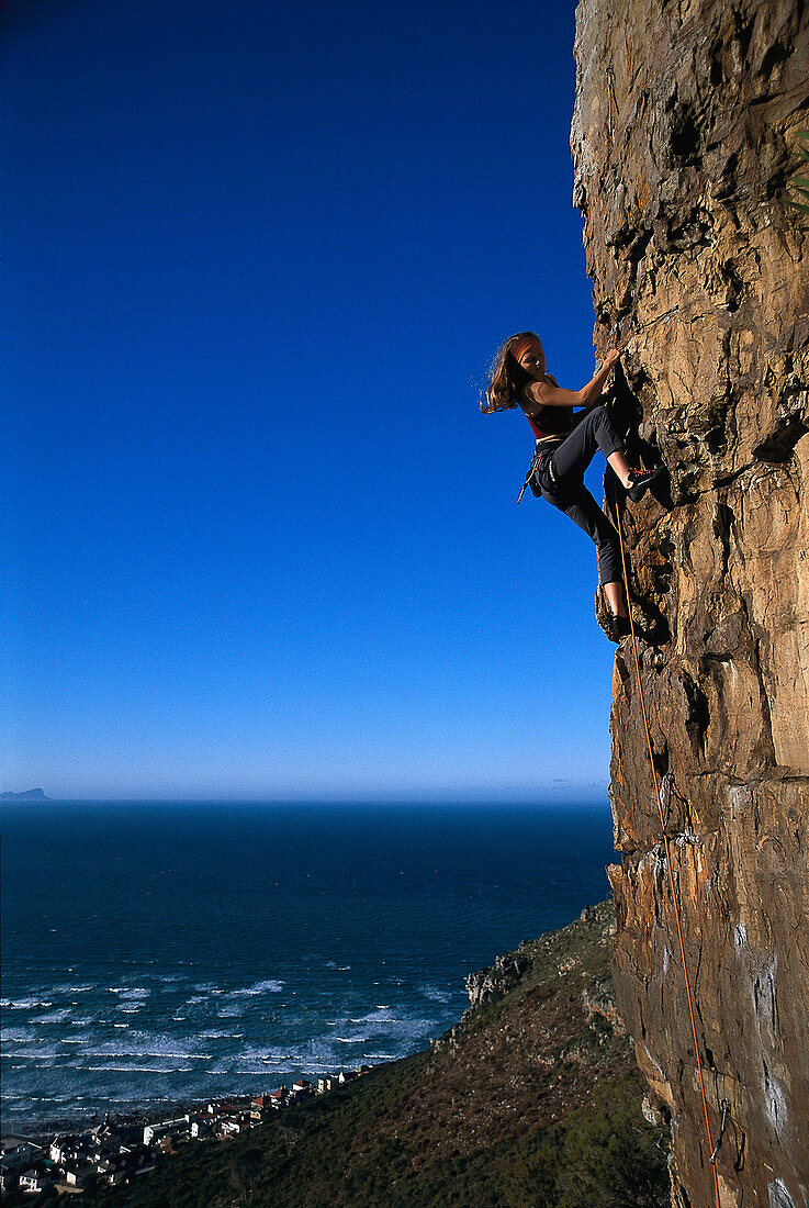 Woman rock climbing, Cape Town Bay, South Africa