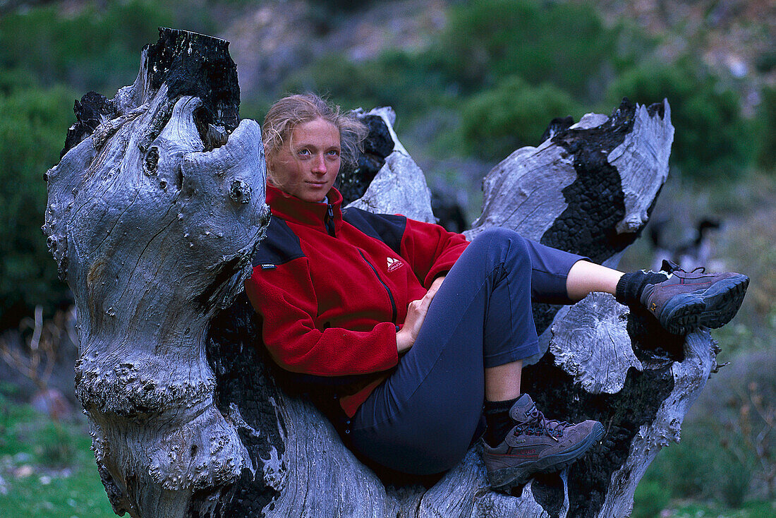 Frau macht eine Pause, sitzt auf einem alten Baum, Wanderung, Südafrika