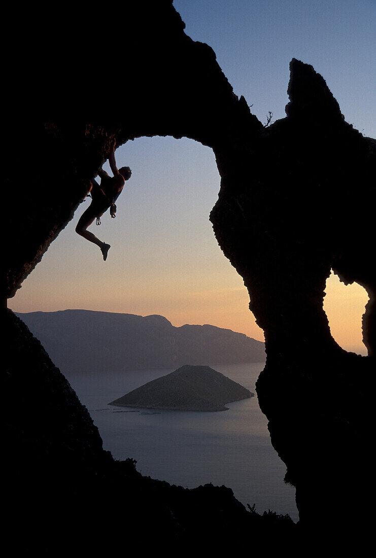 Male free climber scaling rock face, Kalymnos, Dodecanese, Greece