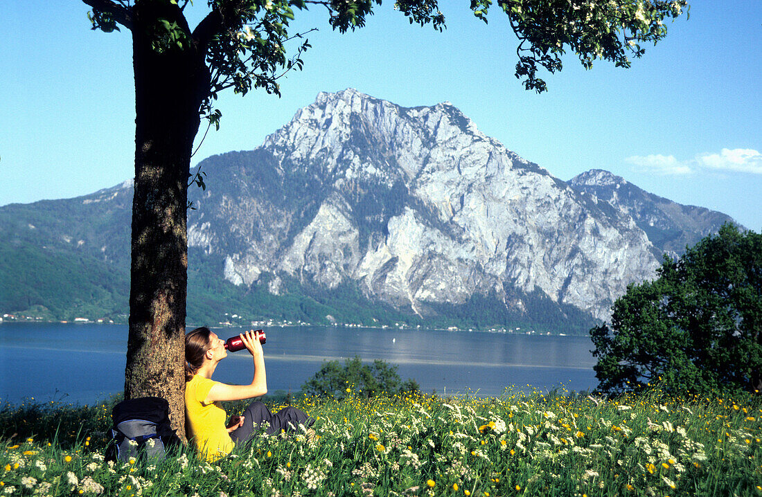 Girl having a rest in a field of flowers, Traun Lake, Traunstein, Salzkammergut, Austria