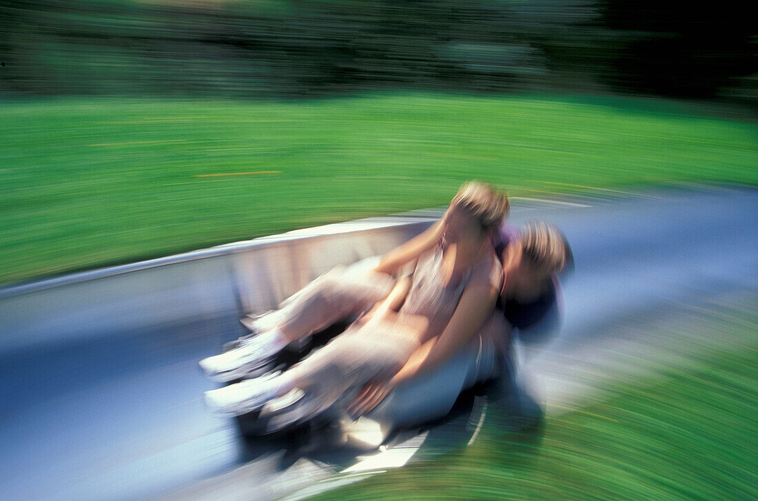 Junges Paar auf einer Sommerrodeln, Strobl, Salzburger Land, Österreich