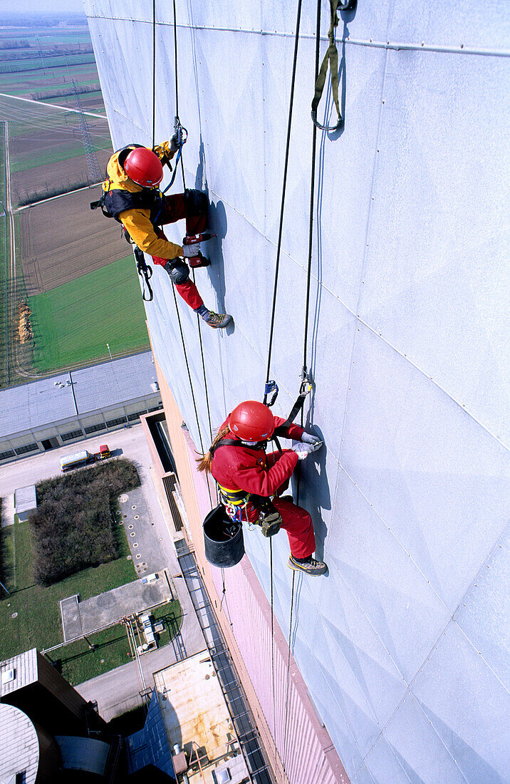 Zwei Arbeiter arbeiten an Seilen an vertikaler Metallfläche, Renovierungsarbeiten, Kraftwerk Dürnrohr, Zwentendorf an der Donau, Niederösterreich