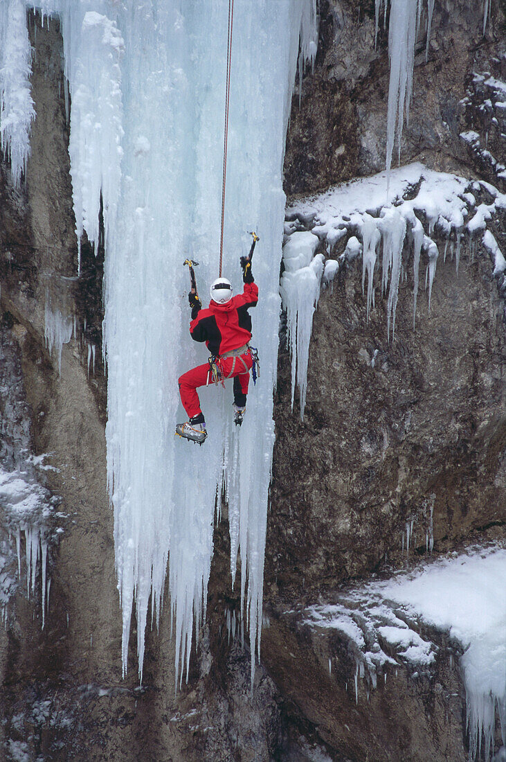 Man climbing up a frozen waterfall, Strubklamm, Salzburger Land, Austria