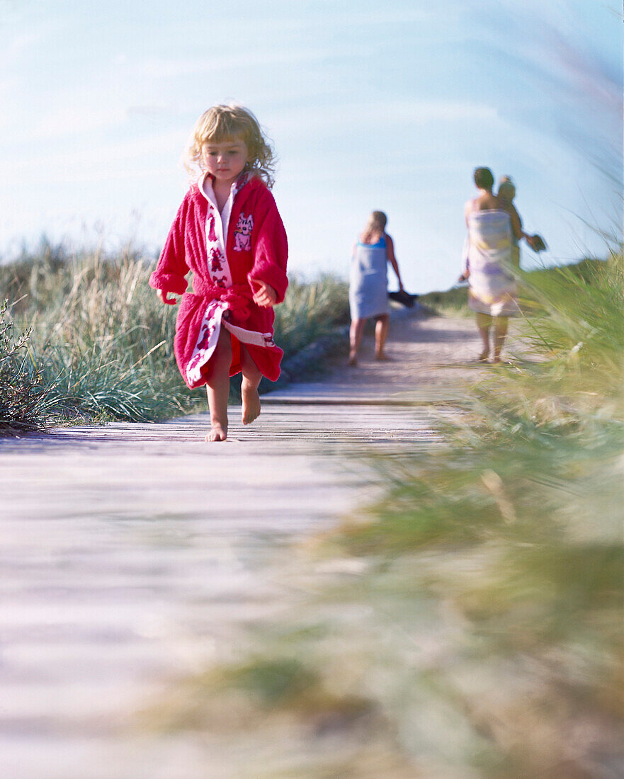 Ein Mädchen läuft entlang einen Holzweg, Südküste Bornholm, Dänemark