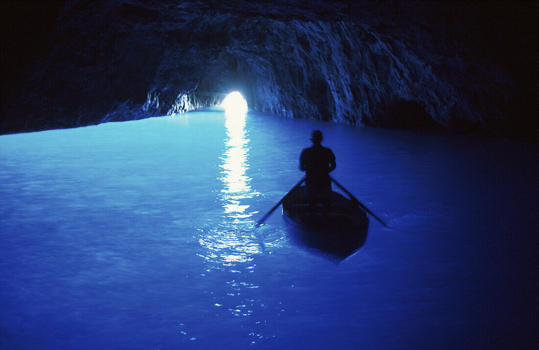 Person in a rowing boat in the Blue Grotto, Capri, Campania, Italy, Europe