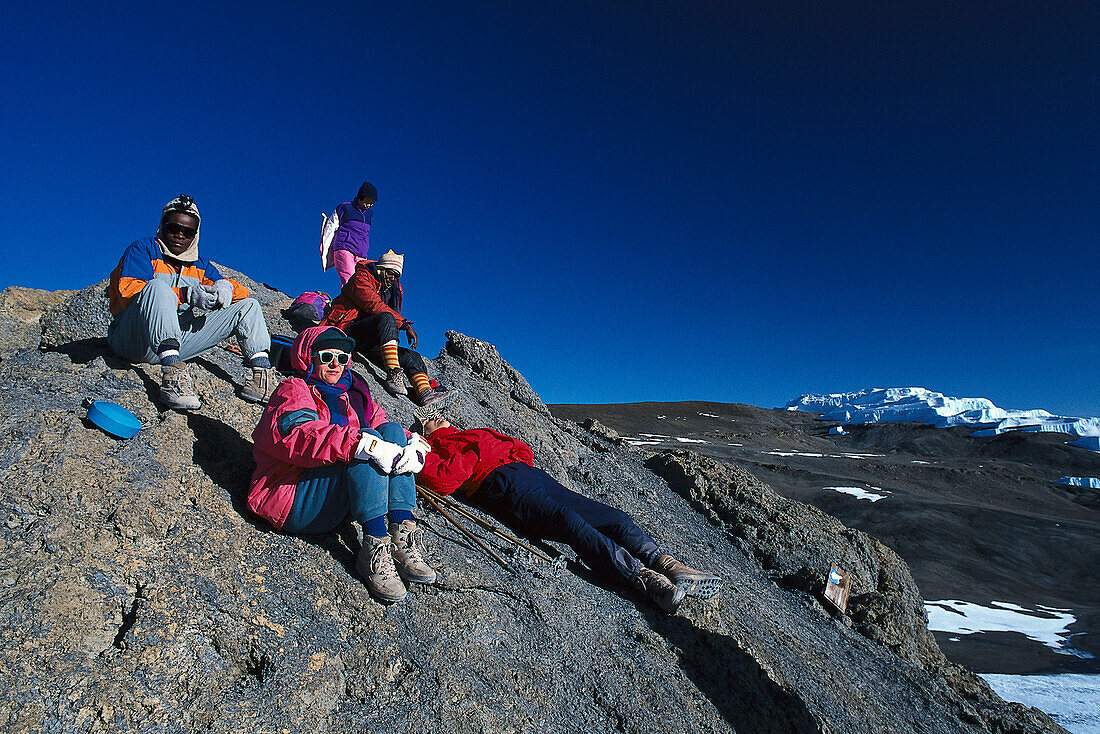 Bergsteiger rasten am Gilman´s Point unter blauem Himmel, Kibo, Kilimanjaro, Tansania, Afrika