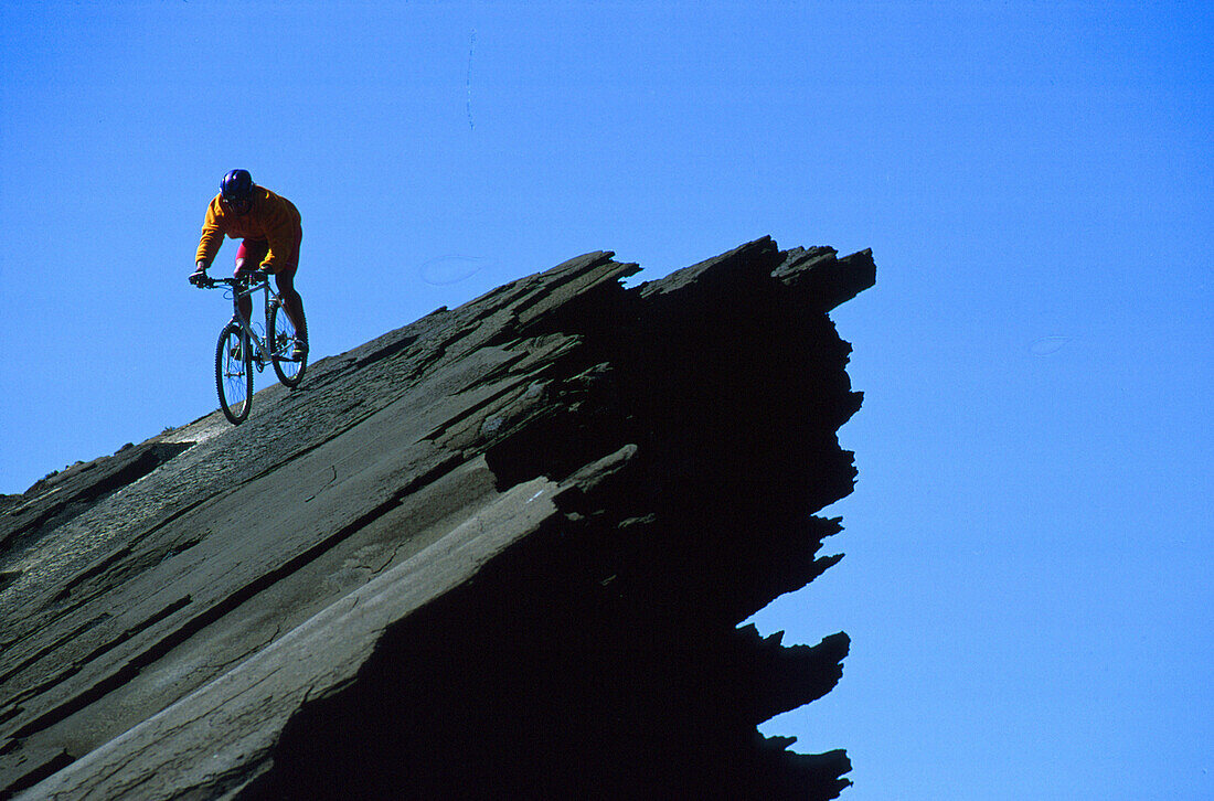 Mountainbiker auf Klippe, Lanzarote Kanarische Inseln, Spanien