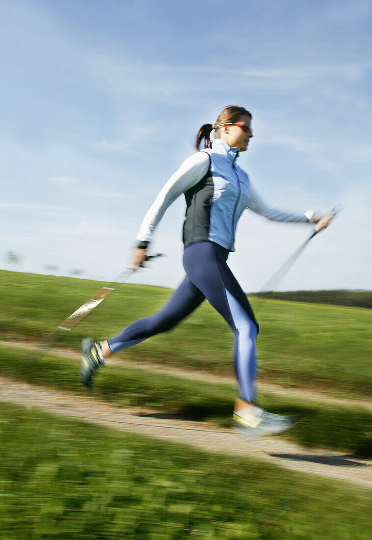 Junge Frau beim Nordic Walking