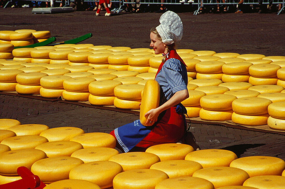 Frau in Tracht erkäuft Käse, Käsemarkt von Alkmaar, Niederlande